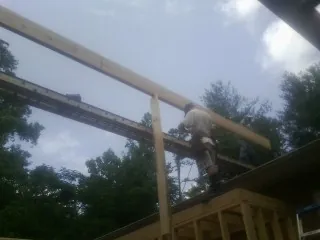 Carpenter setting a ridge beam over a new addition frame — Ice Dam Removal by Roofing Brothers in Sugarloaf