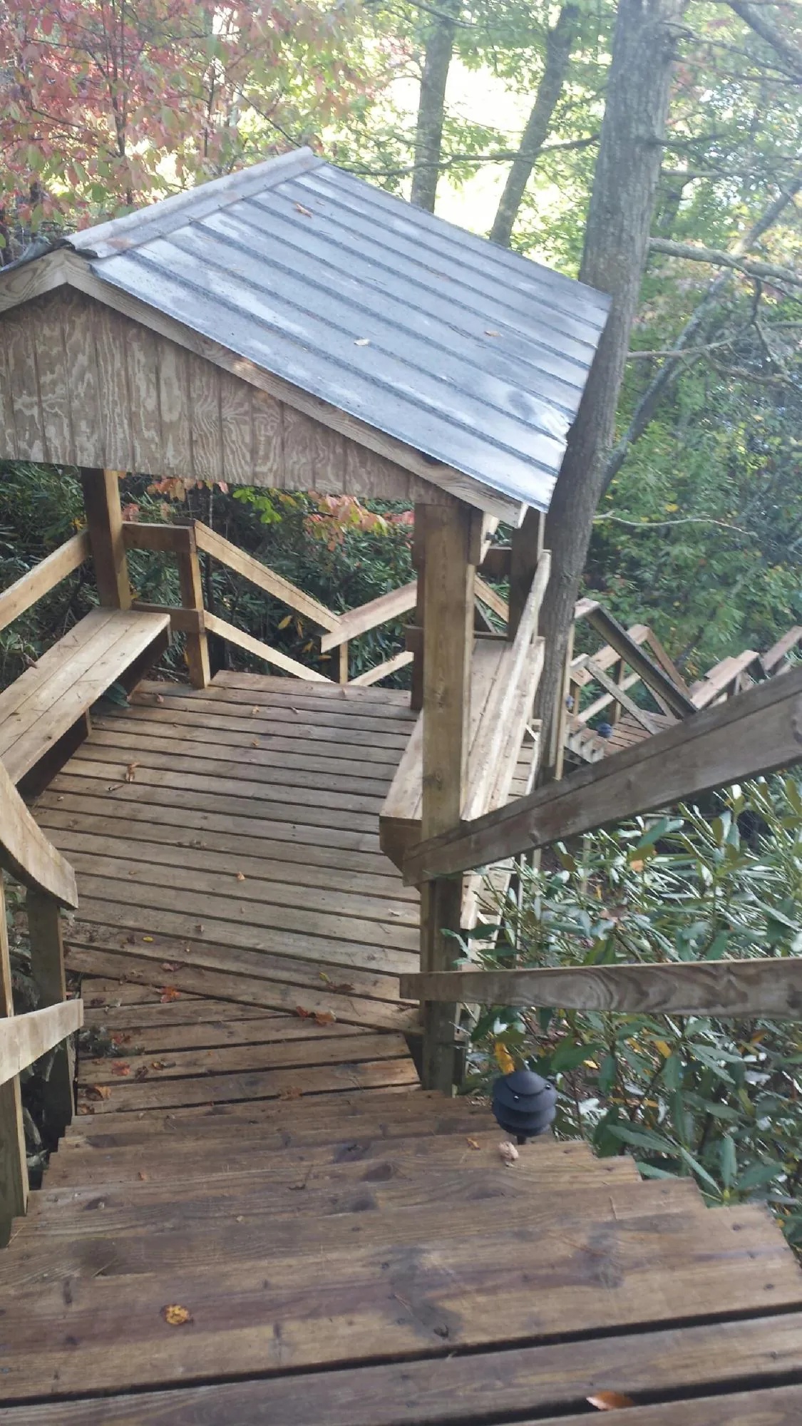 Metal roofed shelter over wooden steps on a wooded walkway — Skylight Repair & Installation work by our crew in Sugarloaf