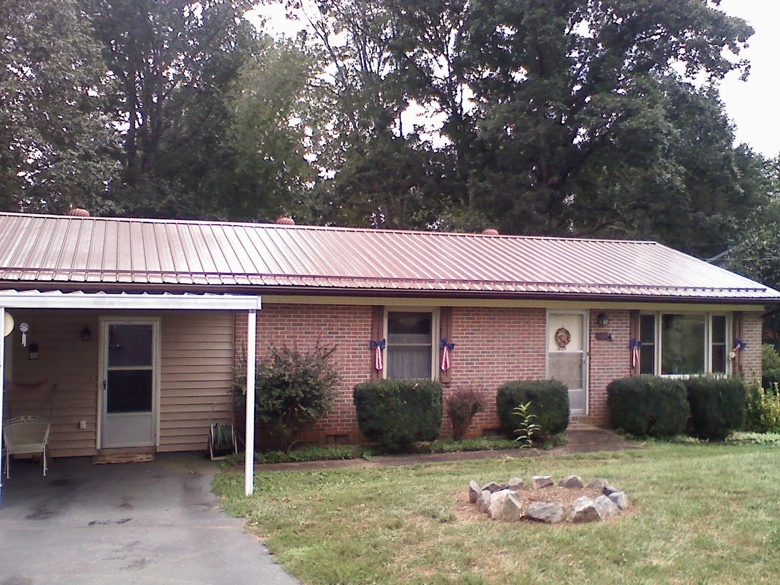 Bronze metal roof and carport on a brick ranch home — Roof Repair work by our crew in Sugarloaf